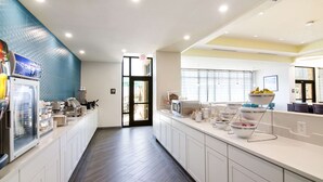 A modern kitchen with a long counter, equipped with various appliances and a refrigerator. - Comfort Inn & Suites Gulf Shores East Beach near Gulf State Park (Gulf Shores)