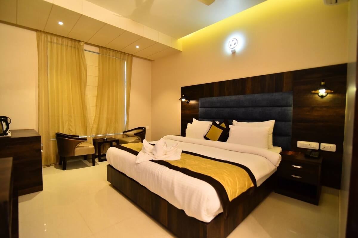 Una habitación de hotel moderna con una cama grande, un escritorio y una silla.