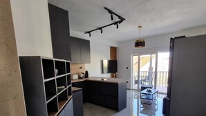 A modern kitchen with dark cabinetry, a marble floor, and a built-in island. - Apartments Bubalo Hvar (Hvar)