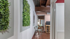A hallway with a green wall, a chair, and a desk.