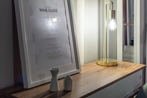 A framed wine guide on a wooden surface with a modern light fixture. - Wine Apartments Florence Ciliegiolo (Florence)