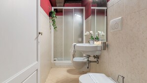 A bathroom with a toilet, sink, and shower.