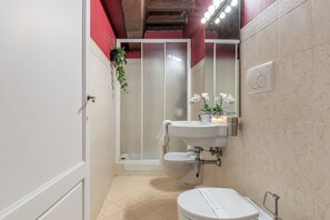 Un bagno con WC, lavandino e doccia.