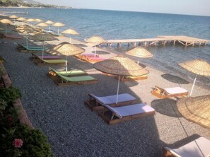 Praia particular, espreguiçadeiras, guarda-sóis