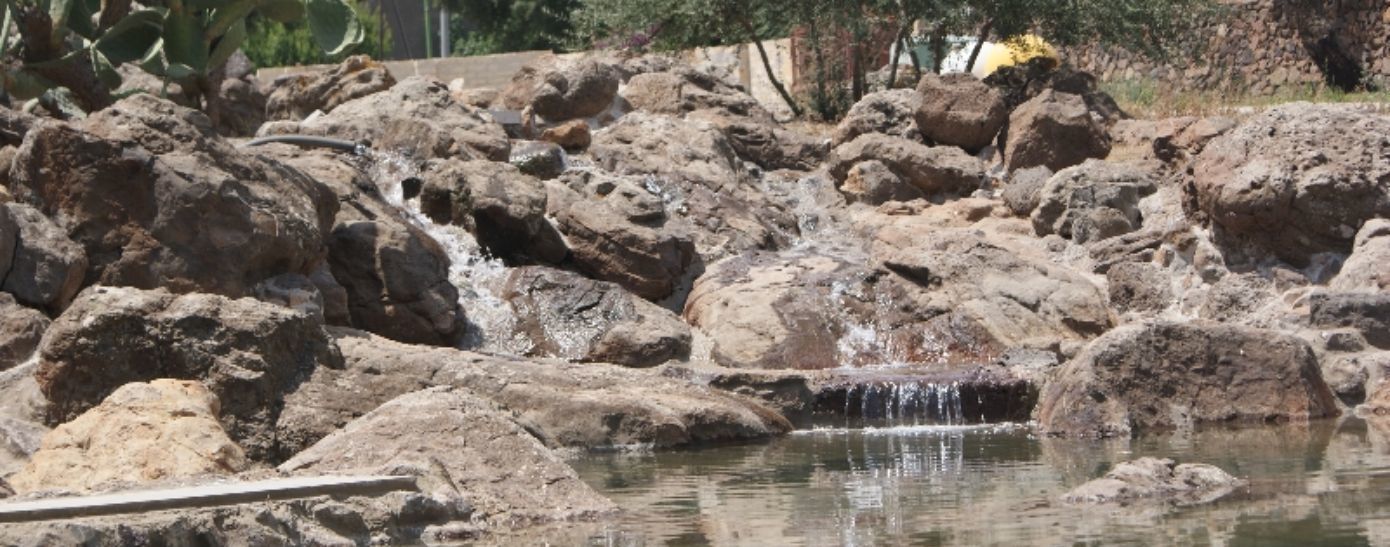Una estructura acuática rocosa con una pequeña cascada.