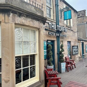 Experience the charm of The Torfin, a hotel bar and brasserie with outdoor seating areas and a welcoming atmosphere.