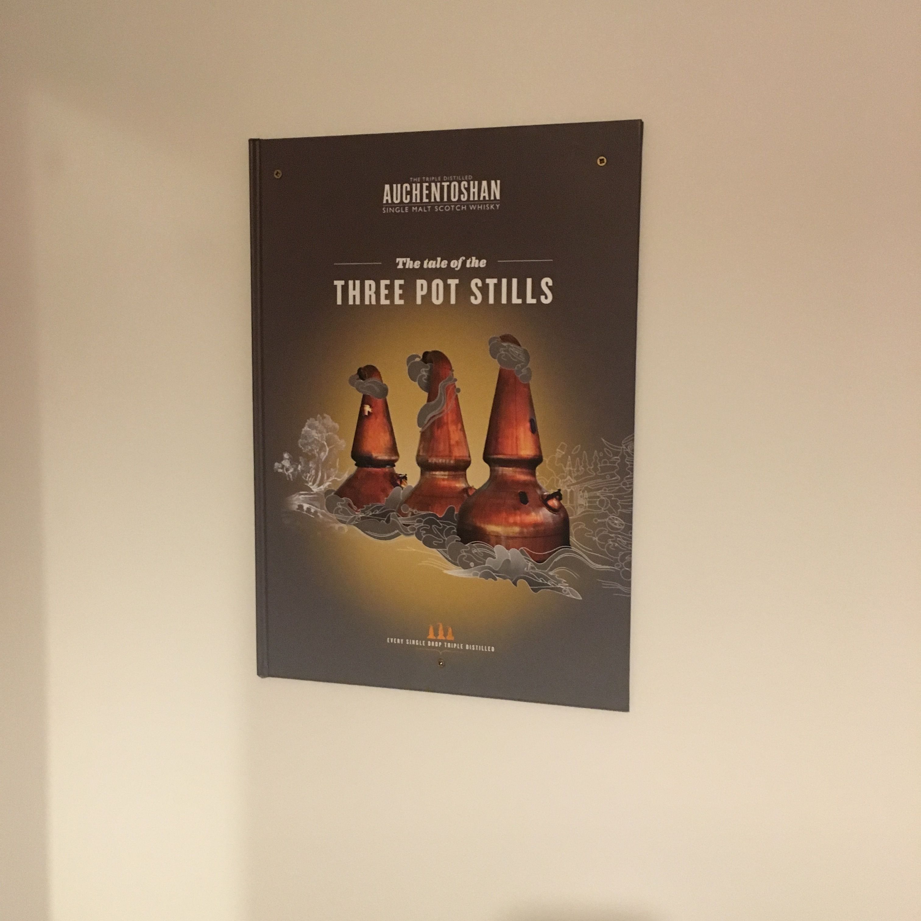 A book titled "The tale of the Three Pot Stills" by Auchentoshan Single Malt Scotch Whisky.