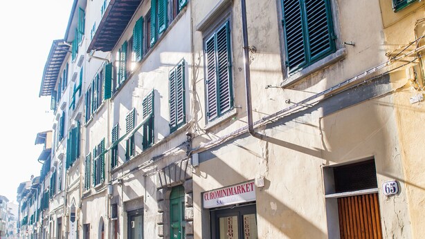 Uma fileira de edifícios com persianas verdes e um letreiro que diz 'CIRCA MARKET'.