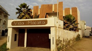 Villa Malaka, a building with a prominent entrance and a sign above the doors. - Villa Malaka (Dakar)