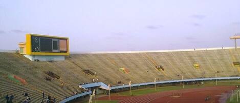 A stadium with a running track, spectator stands, and a scoreboard.