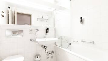 A modern bathroom with a white sink, a handheld showerhead, a toilet, and a glass-enclosed shower area.