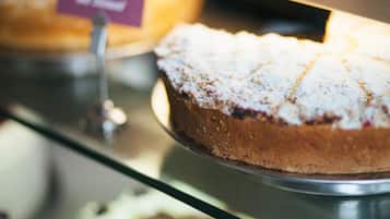 Ein Kuchen mit einer Zuckerstaubschicht, präsentiert auf einem Metallständer.
