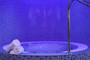 A hot tub with a tiled surround and a metal faucet. - Rezidence Vogelsang (Kasperske Hory)