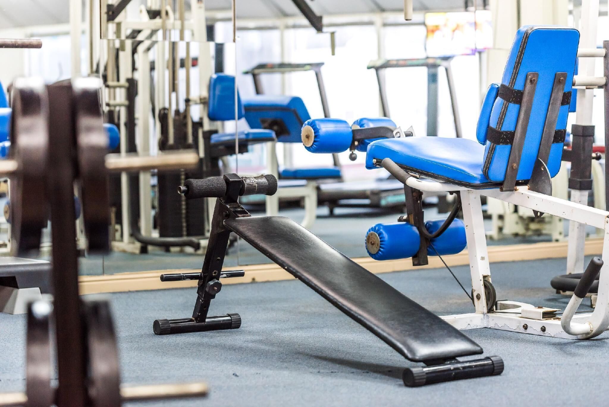 A gym with exercise equipment, including a bench and weight machines.