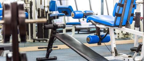 A gym with exercise equipment, including a bench and weight machines.