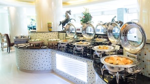 A buffet setup with various food items and a decorative horse statue.