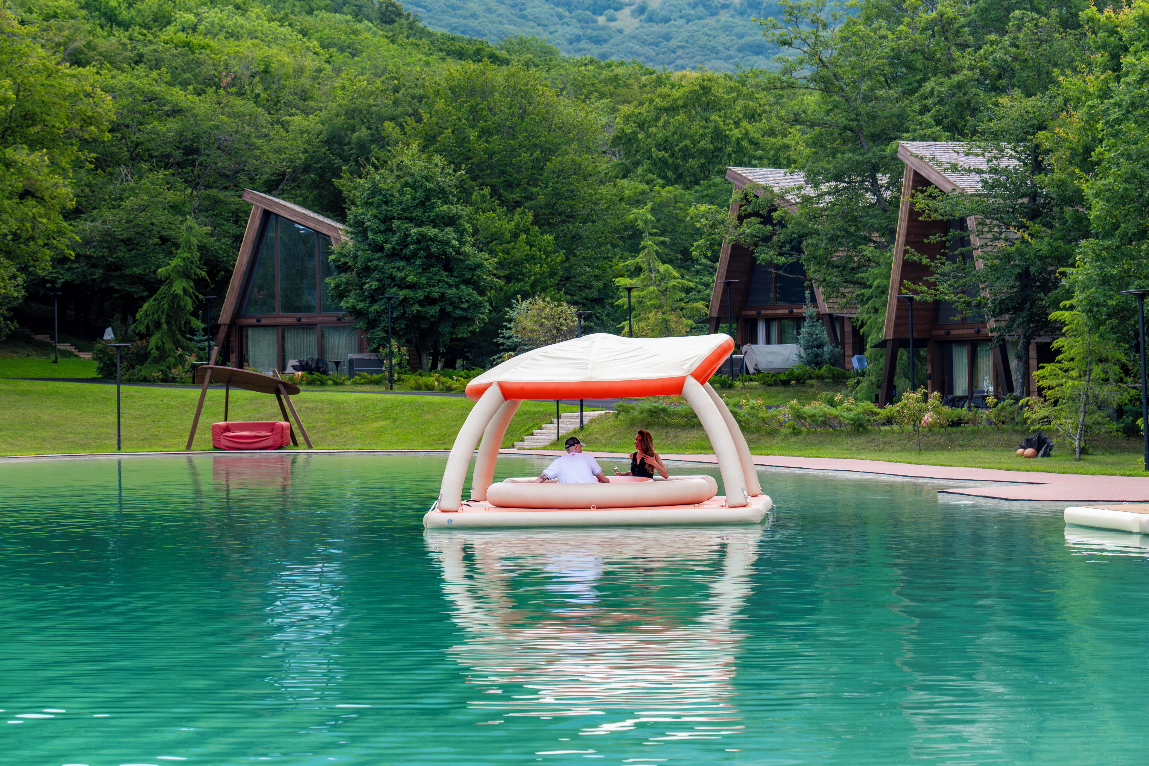 Una piscina amb una estructura flotant i una cadira vermella.