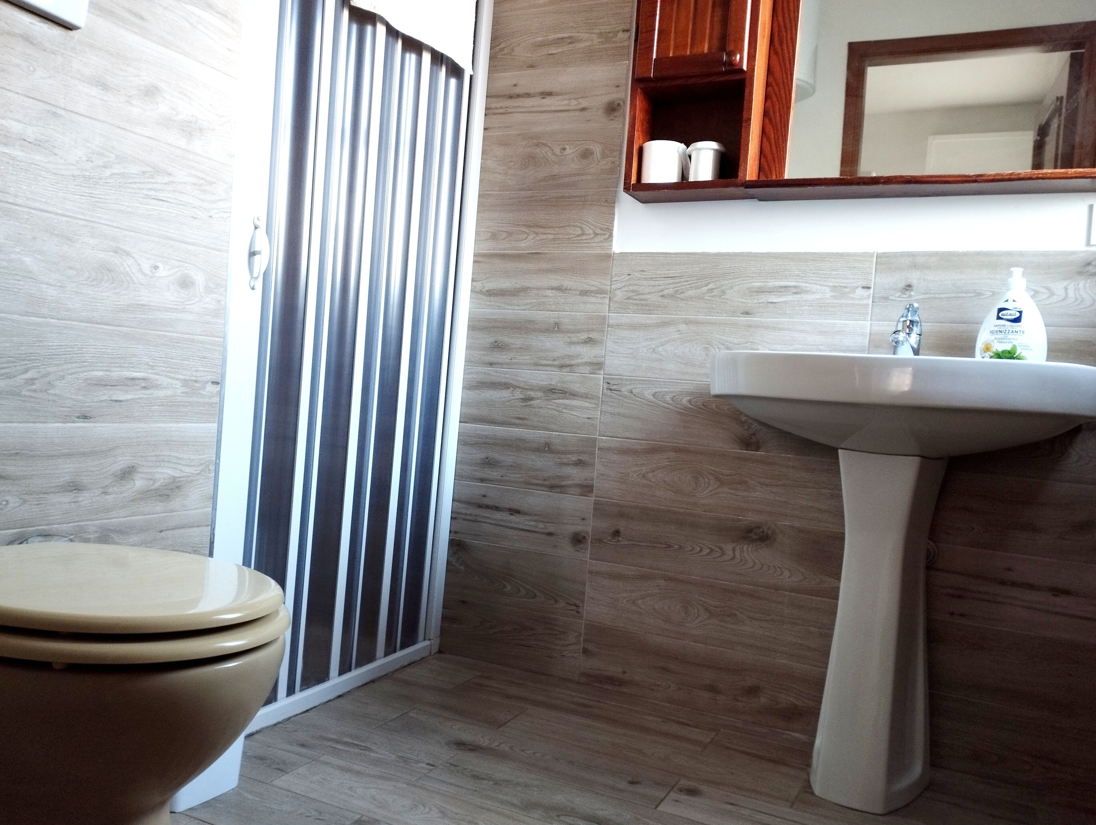 Un baño con inodoro, lavabo y espejo.