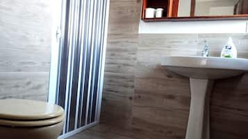 Un baño con inodoro, lavabo y espejo.
