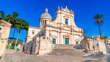 A historic church with a dome, large entrance doors, and a staircase leading up to the entrance.