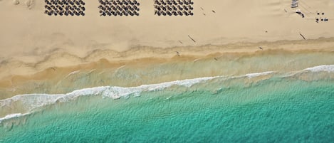 Sulla spiaggia, sabbia bianca, lettini da mare, ombrelloni