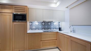 A modern kitchen with wooden cabinets, a built-in microwave, a tiled backsplash, and a stainless steel sink.