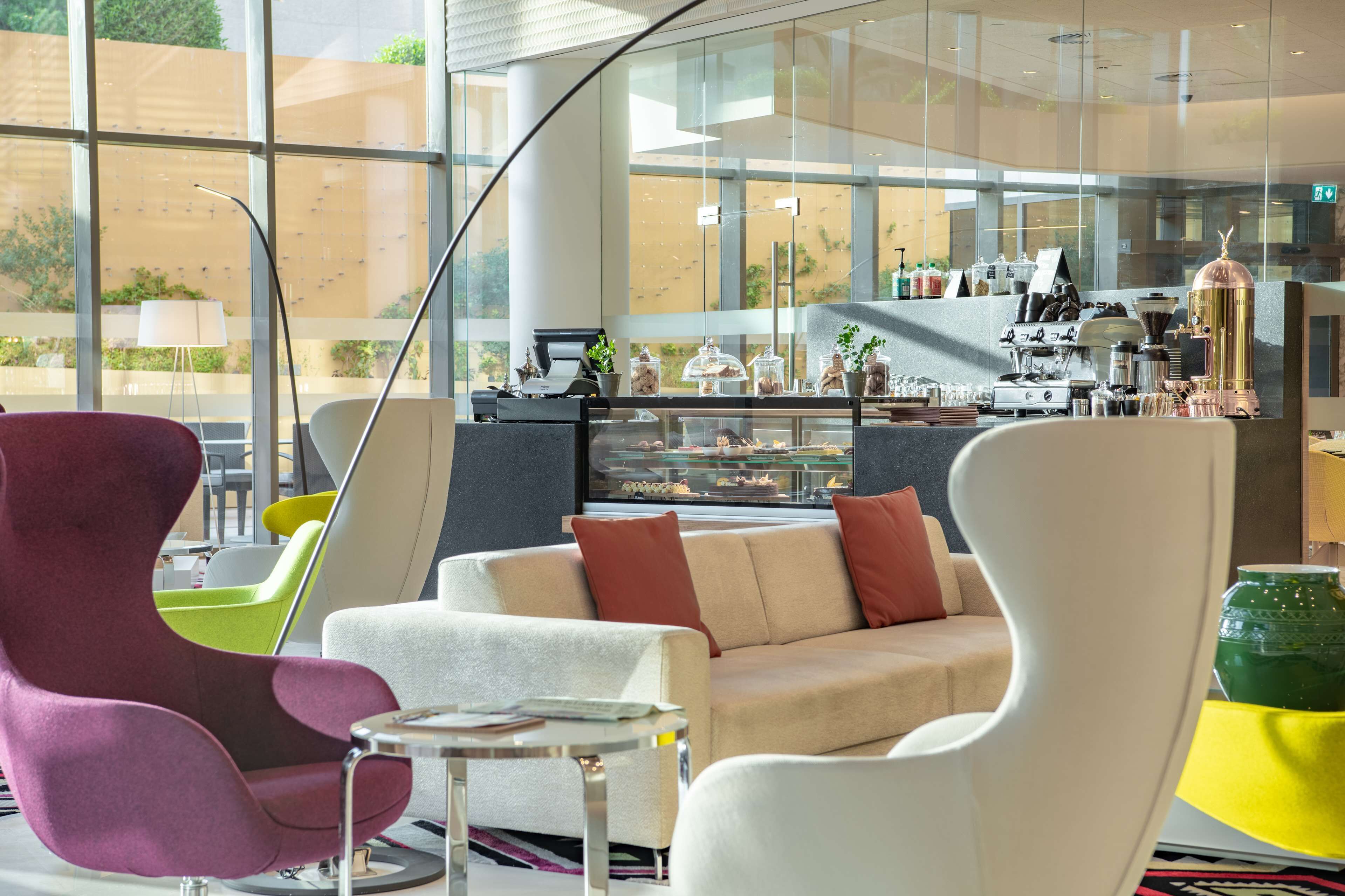 A modern lounge area with a sofa, armchairs, and a coffee station.