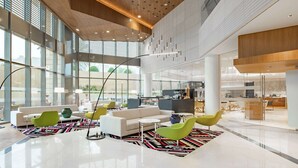 Un'ampia hall con soffitto alto, grandi finestre e arredi moderni.