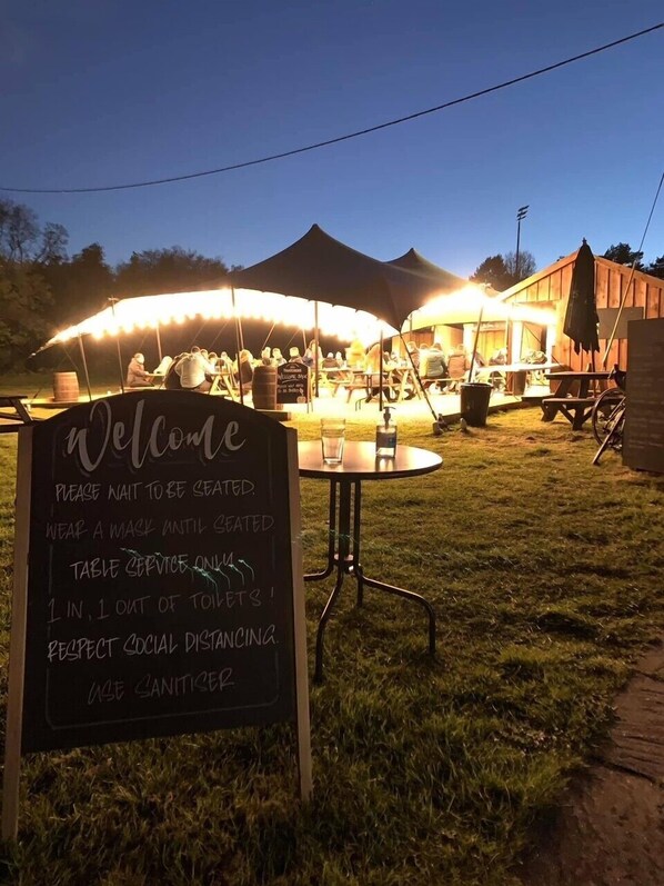 An outdoor dining area with a signboard displaying safety instructions.