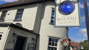 Un edificio tradicional con un cartel que dice 'BLUE BALL Country Pub with Rooms'.