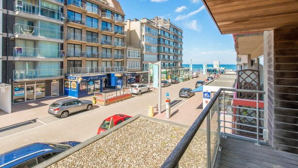 A multi-story hotel with balconies, a parking area, and a view of the beach. - Ines 101 (Koksijde)