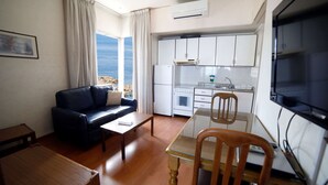 A compact living space with a sofa, dining table, and kitchenette. - Holiday Home Suites (Beirut)