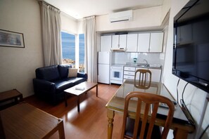 Un espacio habitable funcional con sofá, mesa de comedor y kitchenette.