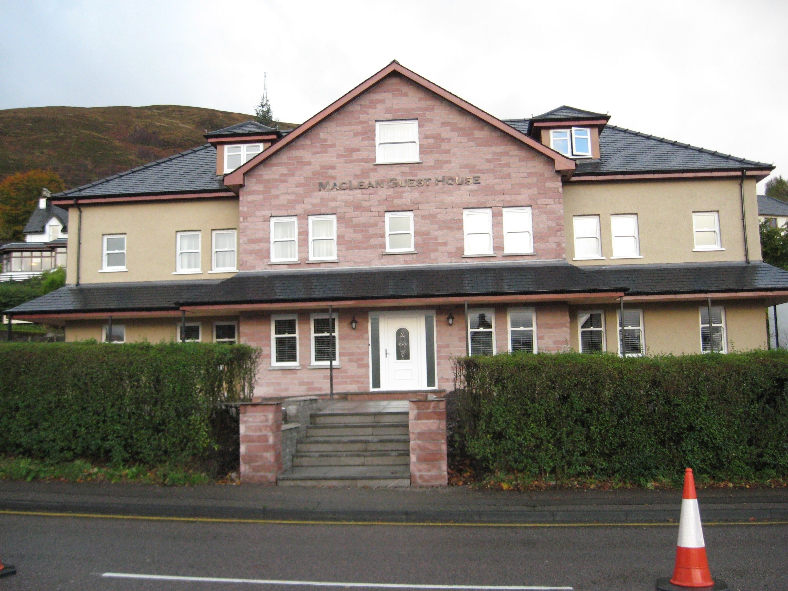 A two-story building with a sign reading "Maclean Guest House."