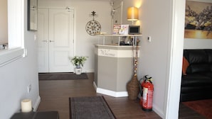 A reception area with a 'Welcome' sign, a lamp, a fire extinguisher, and a plant.