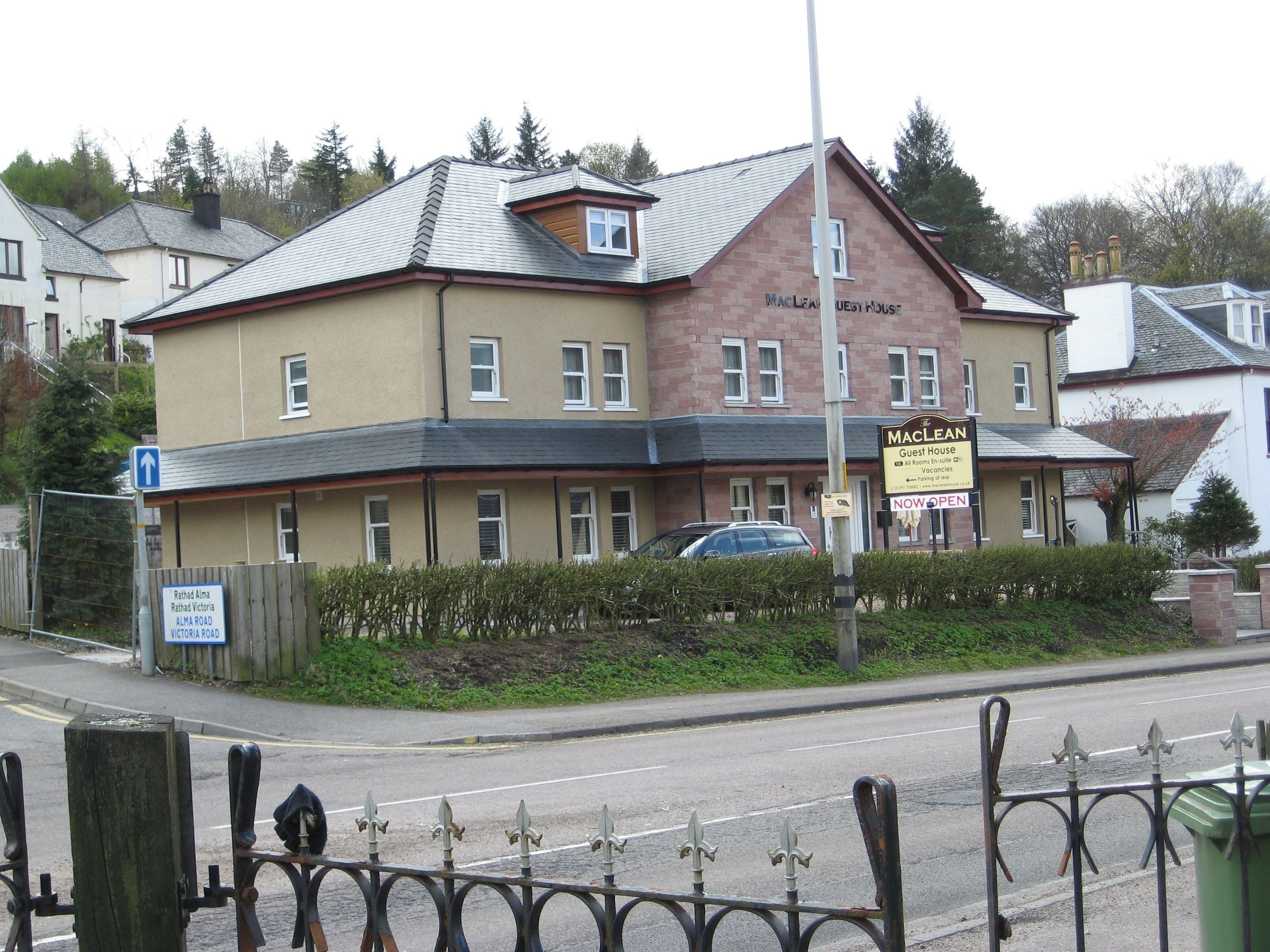 A two-story building with a sign indicating it is a guest house.
