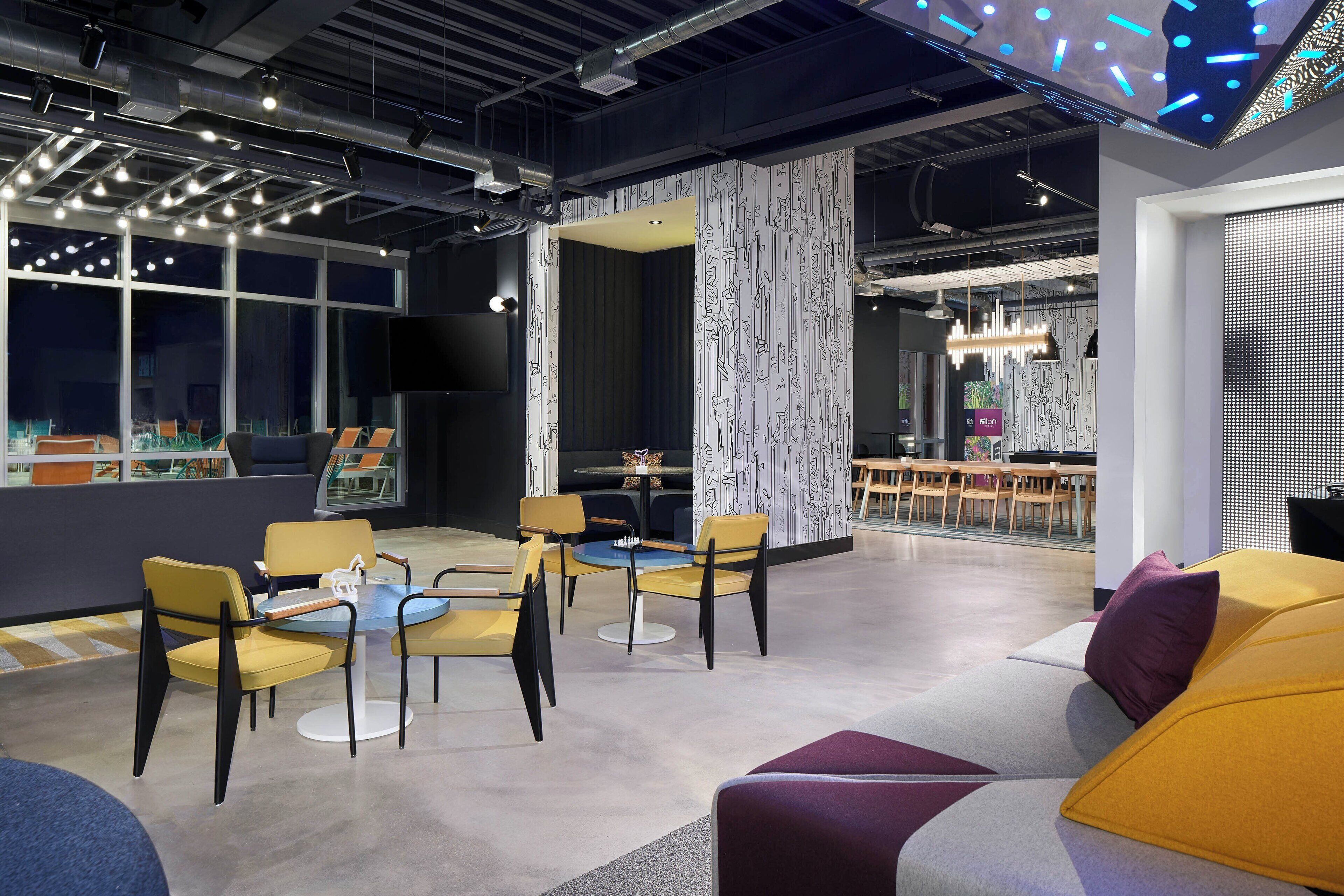 Een modern interieur met een zithoek, een groot raam en een behang met een patroon.