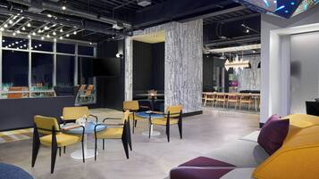 A modern interior with a seating area, a large window, and a patterned wall.