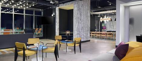 Een modern interieur met een zithoek, een groot raam en een behang met een patroon.