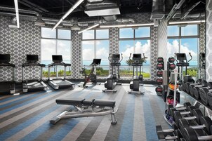 A gym with treadmills, elliptical machines, and free weights.
