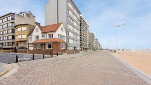 En asfalterad gångväg leder fram till en rad flerfamiljshus med en blandning av olika arkitektoniska stilar.