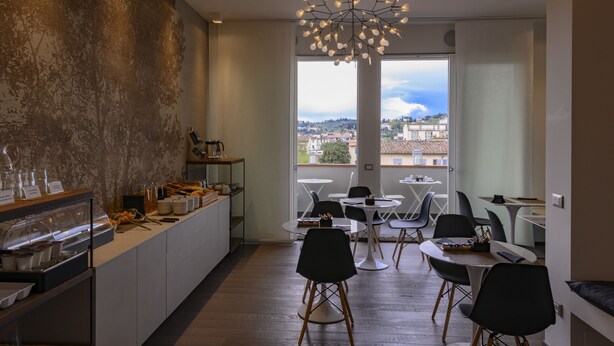 A modern kitchen with a buffet area, large windows with a city view, and contemporary furniture. - B&B The Attico (Florence)