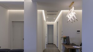 A modern hotel lobby with a wooden floor, a reception desk, and a minimalist decor. - B&B The Attico (Florence)