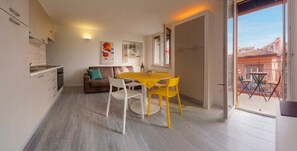 Un espace de vie compact comprenant un coin repas, une kitchenette et un balcon avec vue.