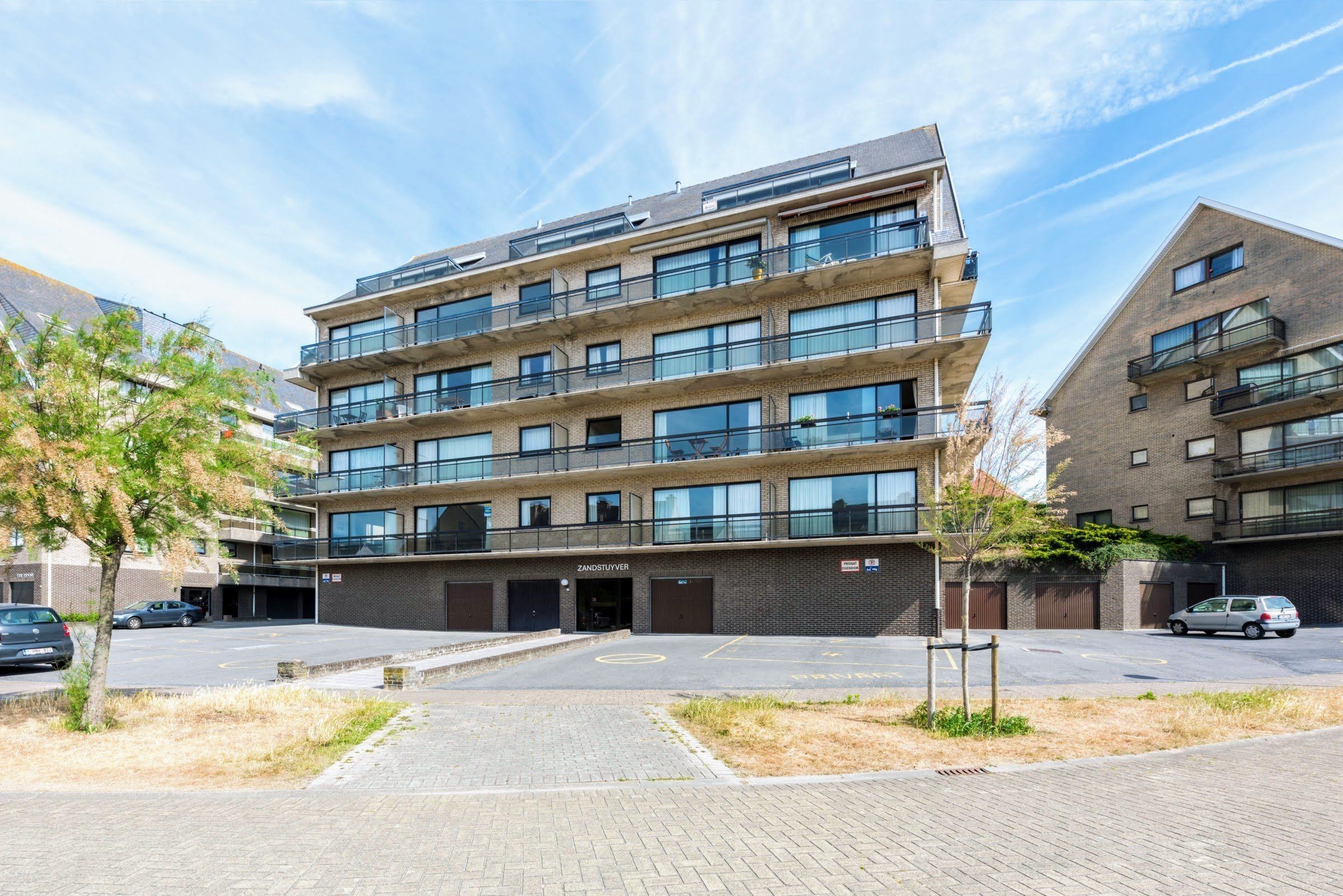 A multi-story building with a modern design, featuring balconies and large windows.