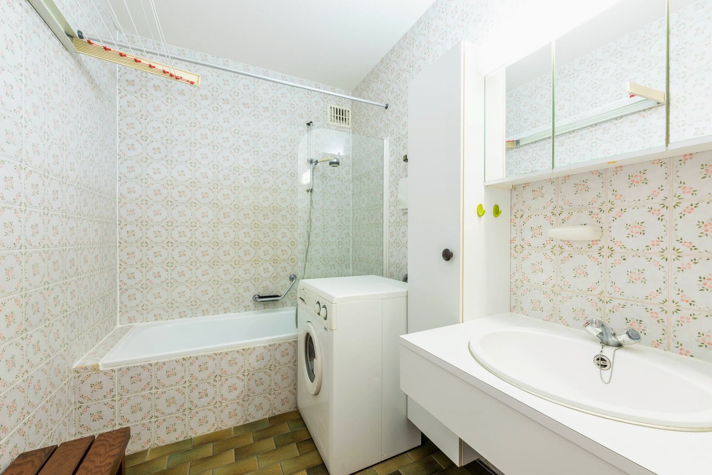 Un baño con lavadora, bañera y lavabo.