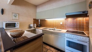 A kitchen with a microwave, toaster, sink, and stove. - Zandstuyver 102 (Koksijde)