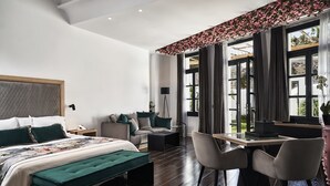 Une chambre à coucher moderne, avec un lit, un bureau et une chaise. Il y a une fenêtre avec des rideaux et une vue sur l’extérieur.