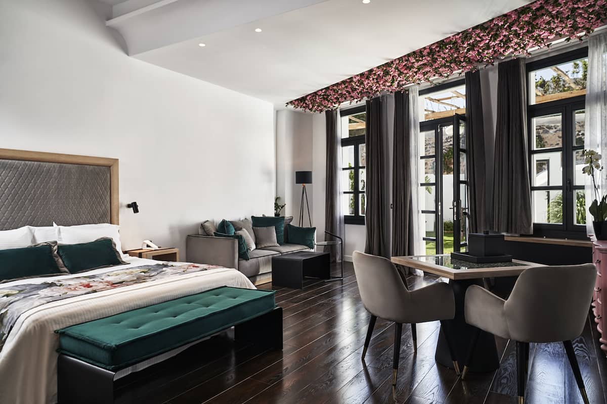 Une chambre à coucher moderne, avec un lit, un bureau et une chaise. Il y a une fenêtre avec des rideaux et une vue sur l’extérieur.