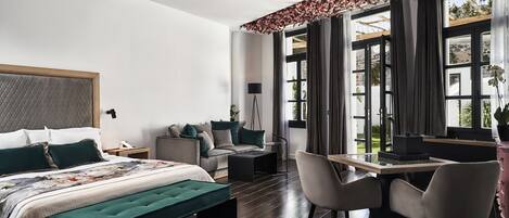 Un dormitorio moderno con cama, escritorio y silla. Se ve una ventana con cortinas y vistas al exterior.